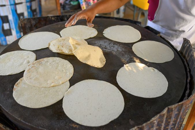 Crop chef preparing tortilla on pan in kitchen