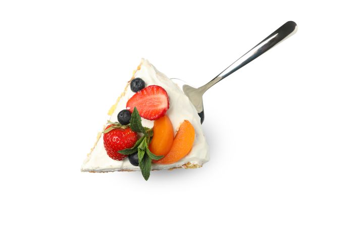 Shovel with berry cream cake isolated on plain background