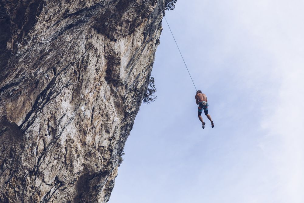Anonymous climber handing on cliff