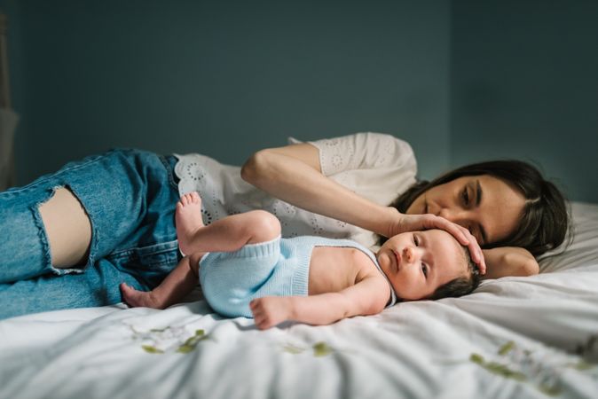 Mother and baby lying on bed