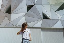 Cheerful woman posing near modern wall