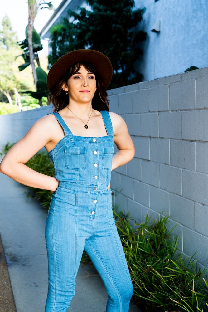 Transgender woman posing outside with hands on hips