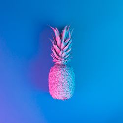 Pineapple in vibrant bold gradient holographic neon  colors on blue background