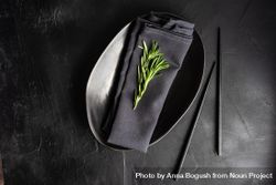 Minimalistic table setting in dark color with rosemary sprig and copy space bxXOnb