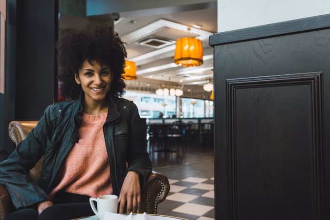 Black woman with afro hair drinking a coffee
