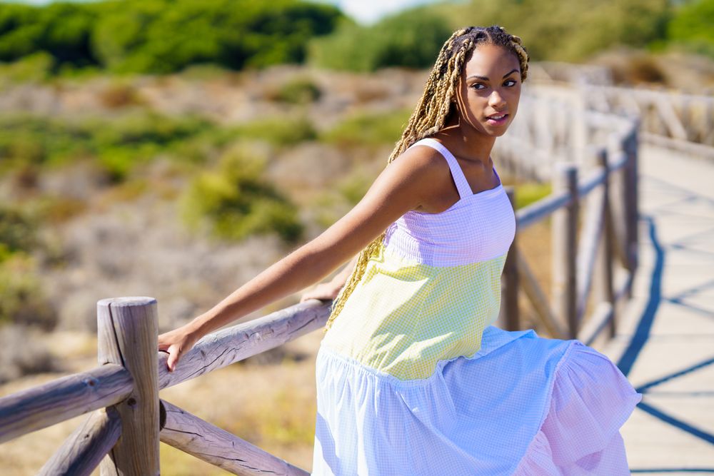 Female hanging on a pedestrian walkway in colorful dress