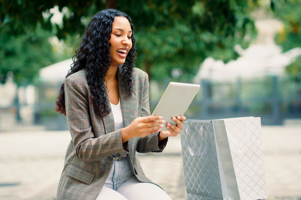 A Joyful Woman Happily Engaging with Her Tablet While Enjoying the Outdoors in Nature