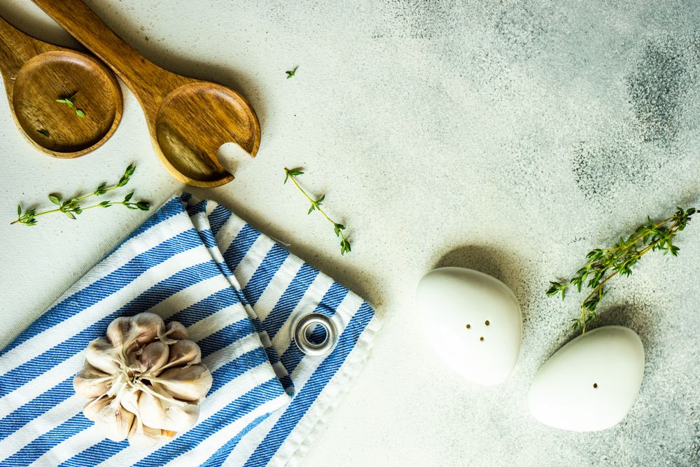 Top view of salt and pepper shakers, thyme and garlic on marble background with copy space