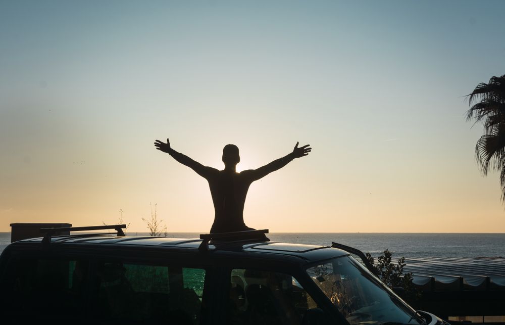 Man enjoying the sunrise in his camped van