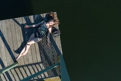 Young female lying down on pier on nature