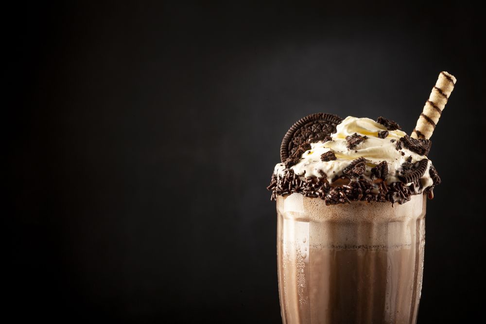 Chocolate milkshake with pieces of chocolate chip cookies.
