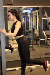 Young Fitness Woman Execute Exercise on Hip with Cable Crossover Machine  in Gym