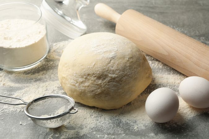 Concept for baking with dough on gray background