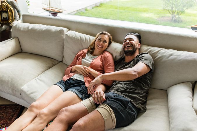 Smiling couple relaxing on sofa in living room