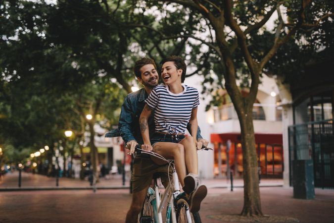 Happy couple riding together on a bicycle