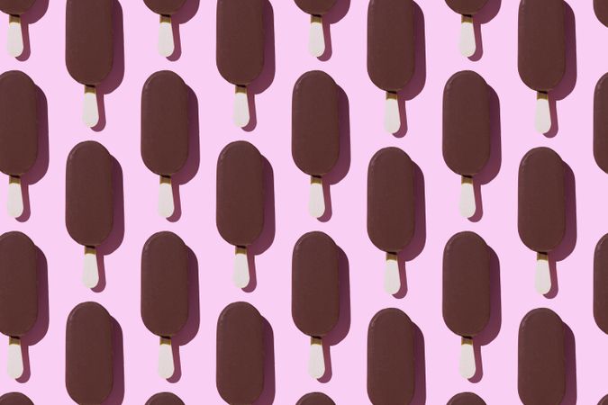 Chocolate popsicle in neat order on pink background