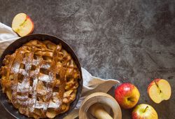 Baked apple pie on table with fruit