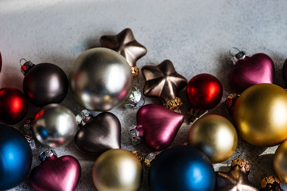 Christmas card concept of colorful baubles ornaments scattered on concrete counter