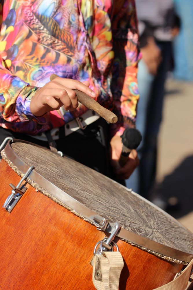 Man in floral button up shirt playing drum