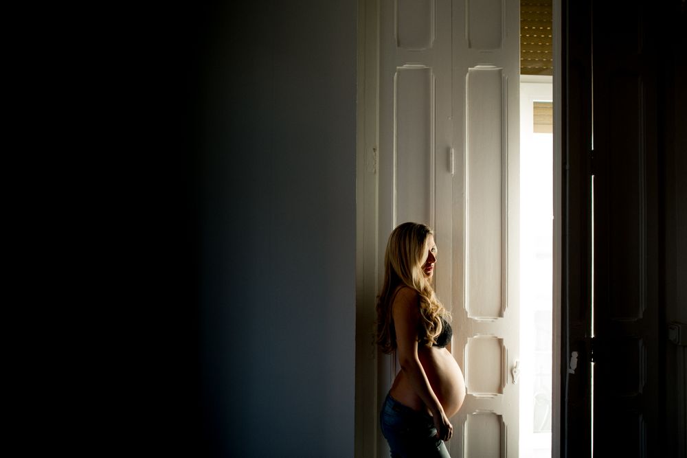 Pregnant woman near open door