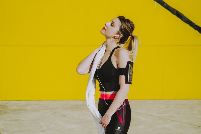 Woman cleaning with sweat towel on yellow background