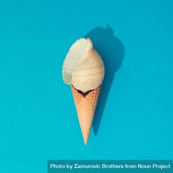 Sea shell in waffle cone on bright blue background 4jXy90