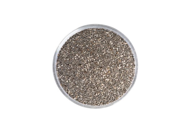 Chia seeds in glass bowl isolated on neutral background