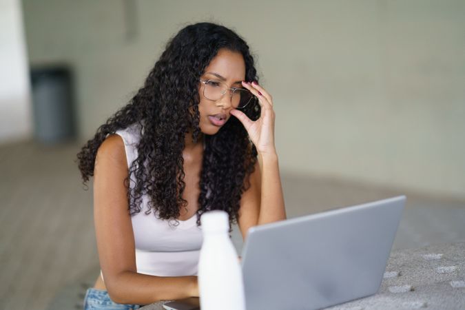 A Focused Woman Engaged in Work on Her Laptop Within a Contemporary Workspace Environment