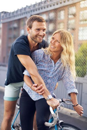 Happy couple with a bike in the city