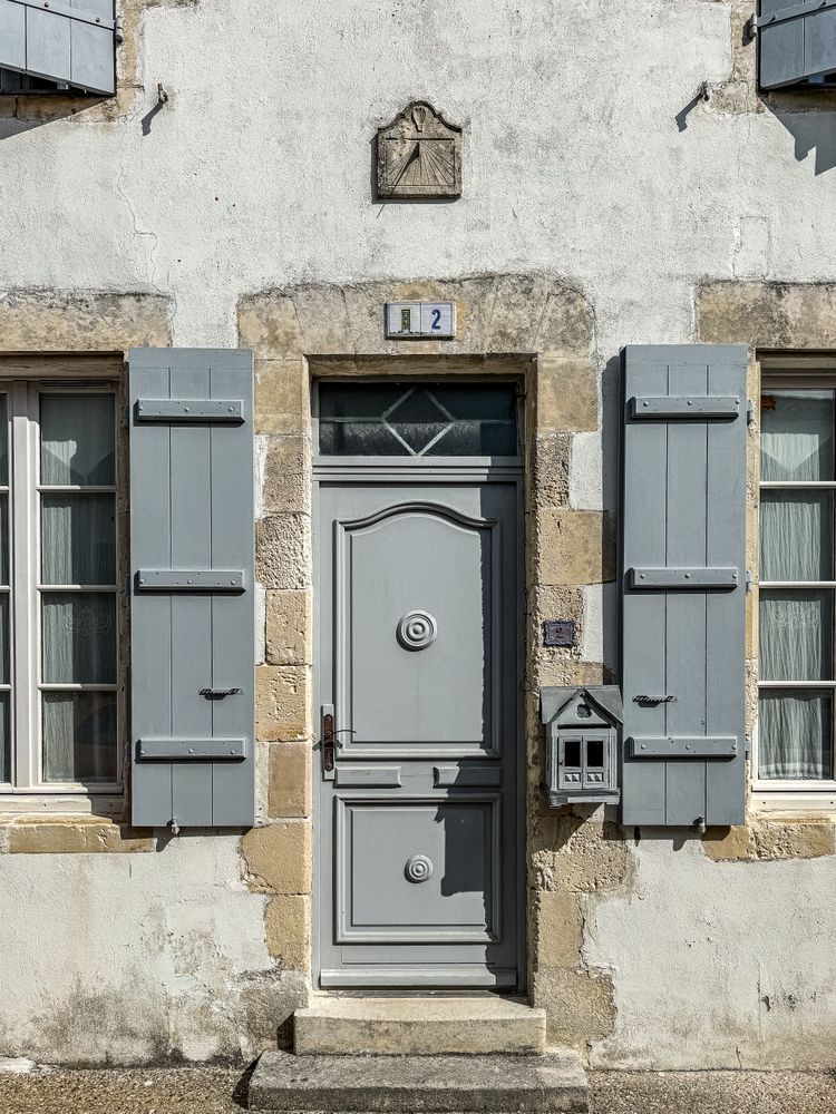 Grey door and sun dial, ile de Ré, France