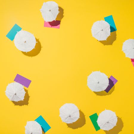 Aerial view of sun umbrellas and multicolored towels on yellow