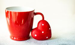 Red mug with dotted heart decoration for St. Valentine's day