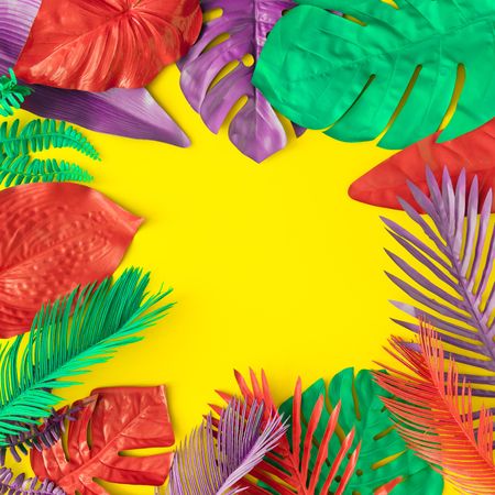 Painted tropical and palm leaves in vibrant bold colors on yellow background
