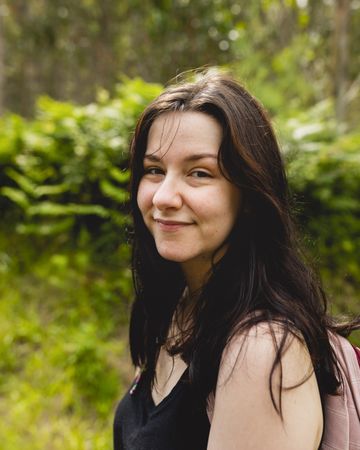 Portrait of a young woman, wearing a t-shirt and brown hair, during a walk in nature