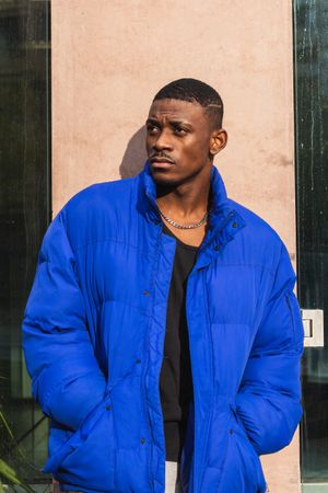 Black stylish man in warm jacket on street