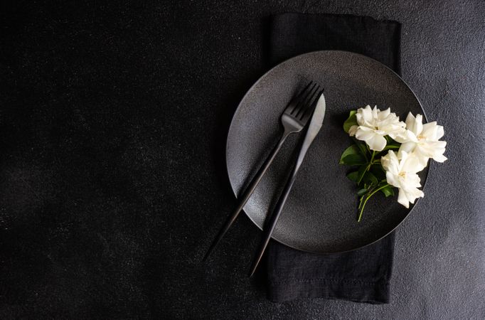 Top view of minimalistic table setting with flower on plate