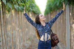 Joyful Woman Embracing and Connecting with Nature in a Beautiful Lush Green Environment