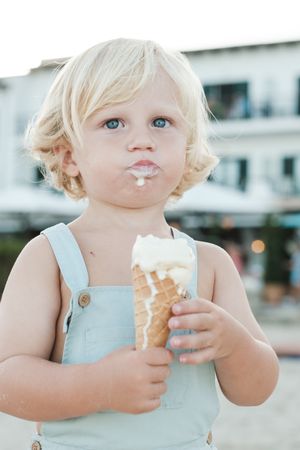 Preschool boy enjoying ice cream on sunny street
