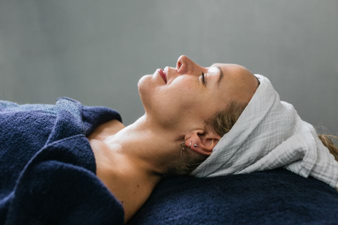 Smiling woman lying on table in beauty salon