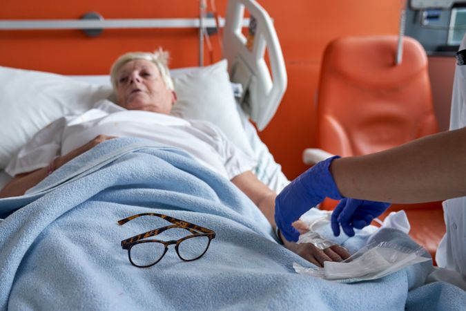 Mature female patient getting intravenous injection on hospital