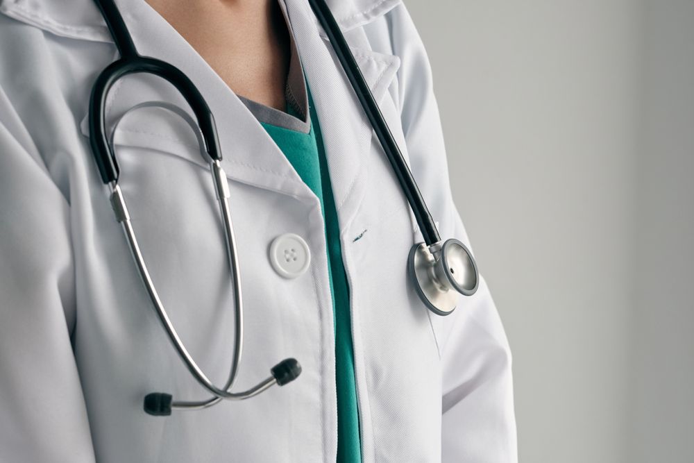 Faceless physician in medical robe with stethoscope