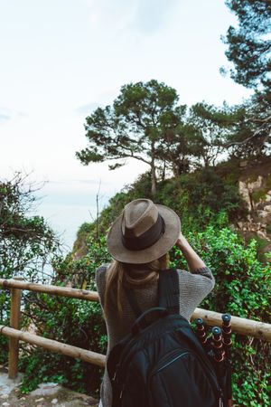 Woman with binocular on coastal walkway