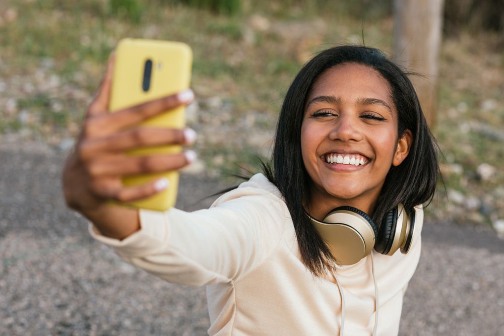 Woman on longboard taking selfie on smartphone