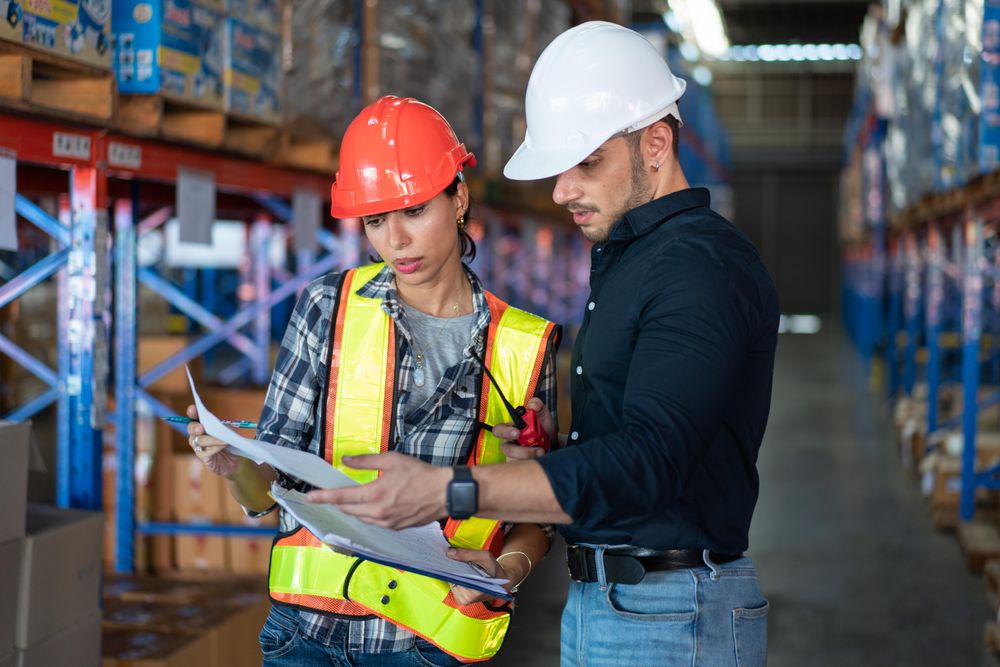 Male and female colleagues checking stock distribution before shipping