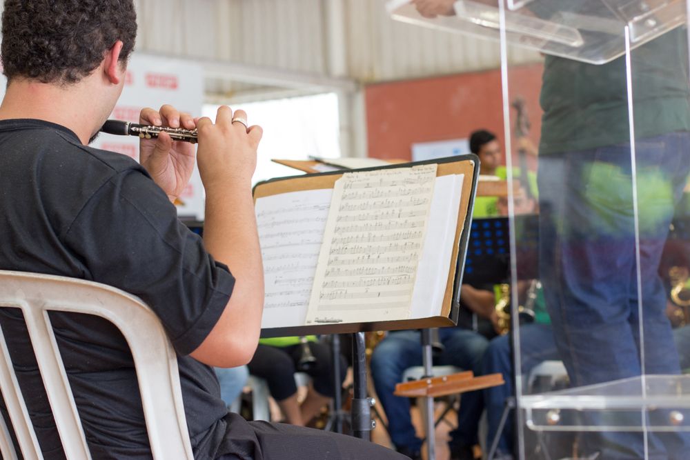 Back view of man playing flute in classroom