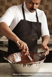 Black male in apron with steel bowl of melted chocolate 0LMGe5