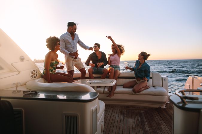 Men and women dancing to music while partying on yacht