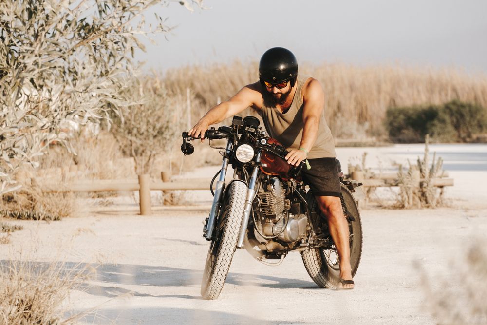 Serious male driving motorcycle in forest