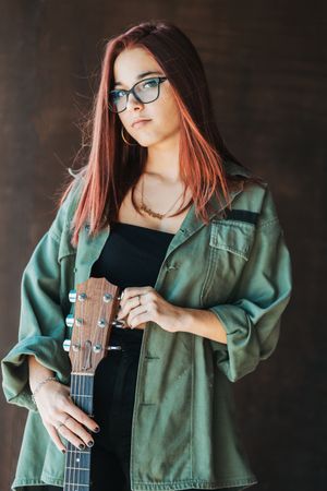 Woman in glasses leaning on wall