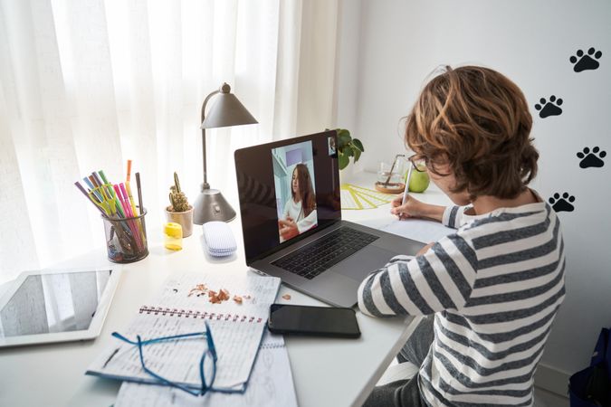 Boy doing homework during video chat with girl